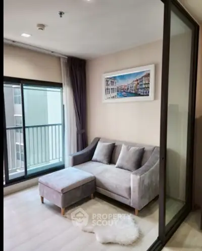 Modern living room with cozy gray sofa and balcony view