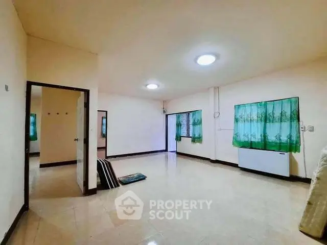 Spacious unfurnished room with tiled flooring and green curtains, ideal for customization.