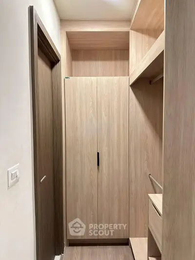 Spacious walk-in closet with modern wooden finish and ample storage space.