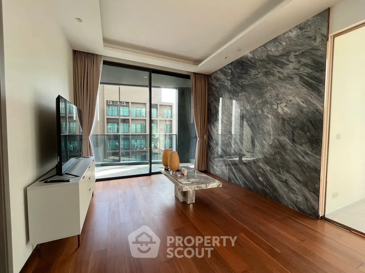 Modern living room with marble accent wall and large windows offering city view