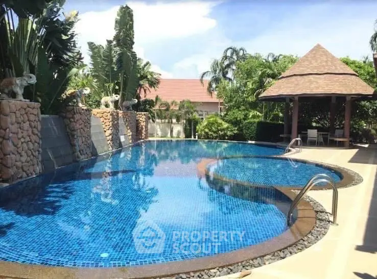 Luxurious private pool with tropical landscaping and gazebo, perfect for relaxation and entertainment.