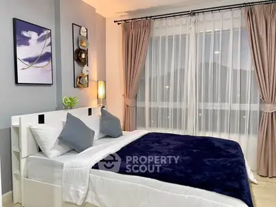 Modern bedroom with stylish decor and large window for natural light.