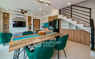 Modern open-plan living room with stylish dining area and staircase, featuring elegant decor and ample natural light.