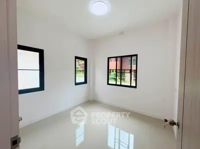 Bright empty room with large windows and glossy tiled floor, perfect for customization.