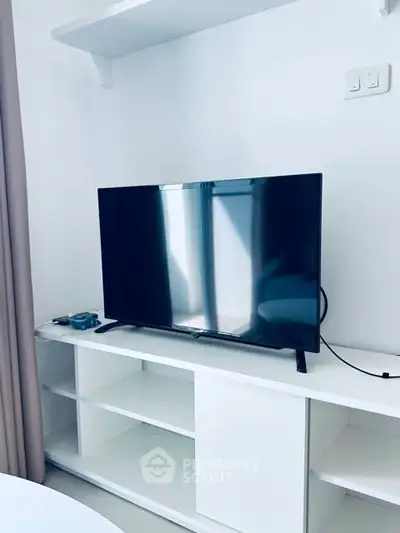 Modern living room with sleek TV and white shelving unit
