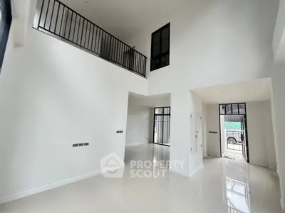 Spacious modern living room with high ceilings and large windows, perfect for natural light.