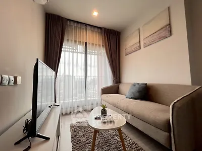 Cozy living room with modern decor and large window offering natural light.