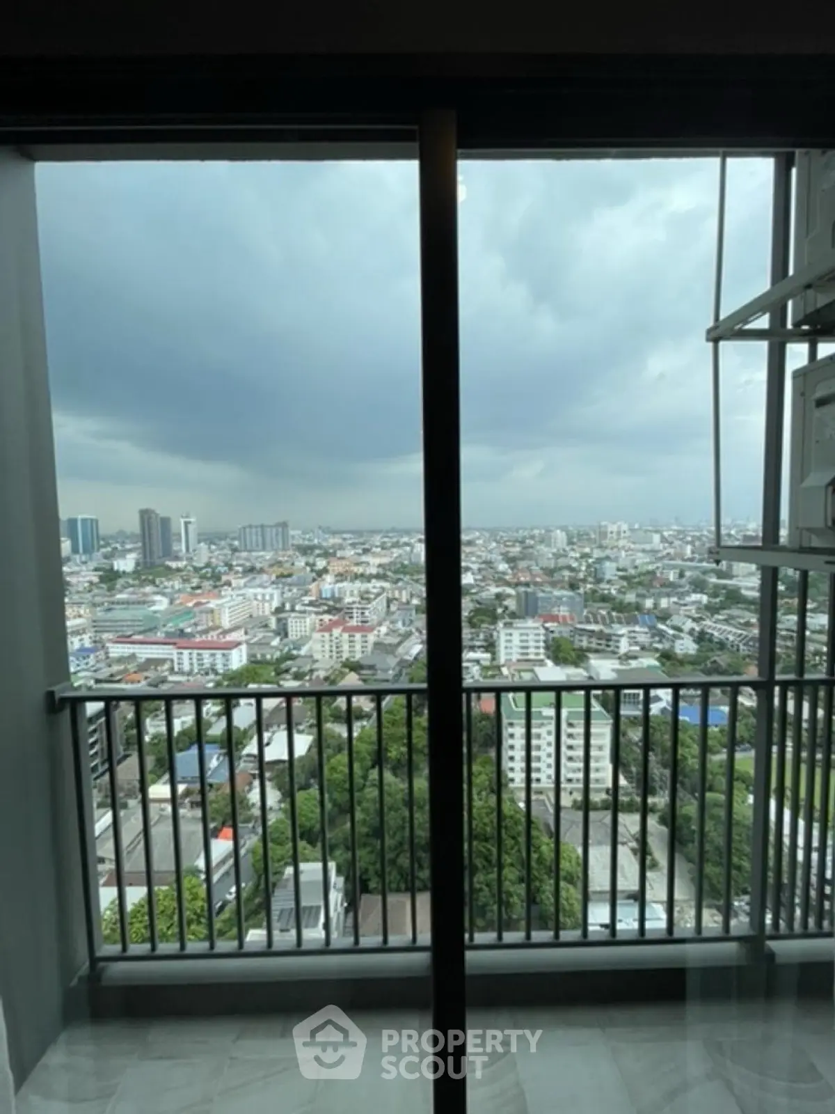Stunning cityscape view from a high-rise balcony with expansive skyline and lush greenery.