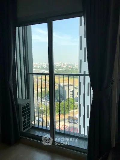 Modern apartment balcony with panoramic city view and sliding glass doors