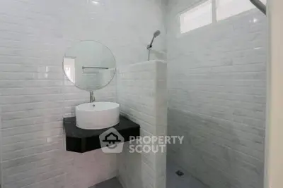 Modern bathroom with sleek white tiles and round mirror