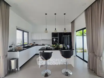 Modern kitchen with sleek design, featuring an open layout and stylish bar stools, perfect for entertaining.