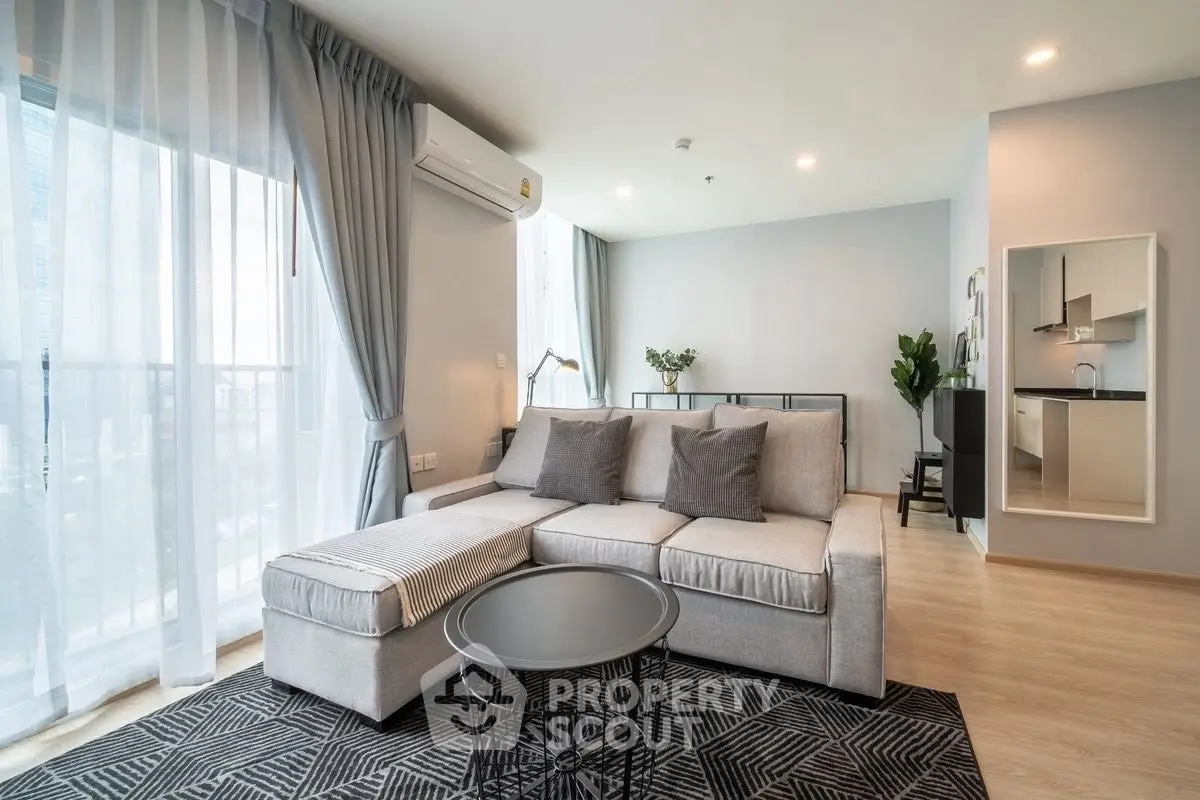 Modern living room with stylish gray sofa and chic decor in a bright apartment.
