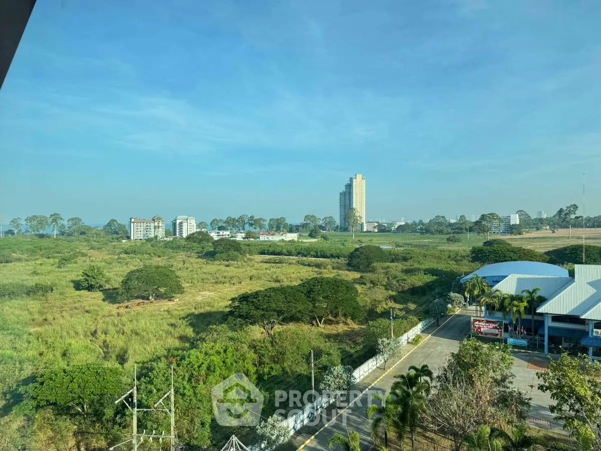 Stunning panoramic view of lush green landscape with distant city skyline, perfect for serene living.