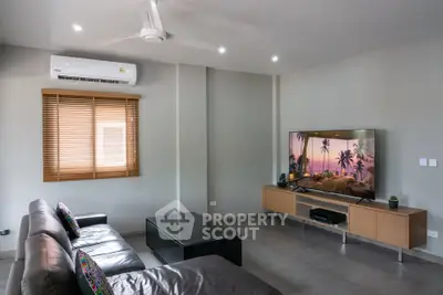 Modern living room with sleek furniture and large TV, featuring air conditioning and stylish decor.