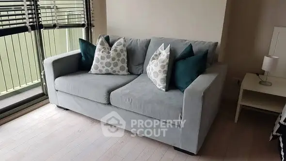 Cozy living room with modern gray sofa and stylish cushions, perfect for relaxation.