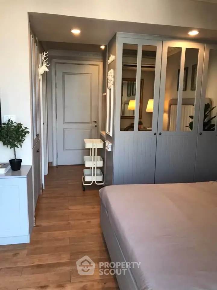 Modern bedroom with stylish wooden flooring and built-in wardrobe