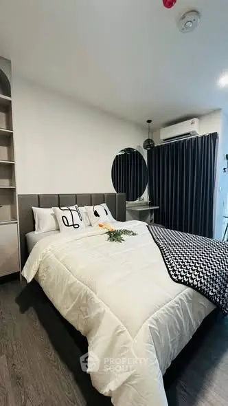 Modern bedroom with stylish decor and cozy bedding in a contemporary apartment.