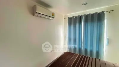 Cozy bedroom with air conditioning and natural light through blue curtains.
