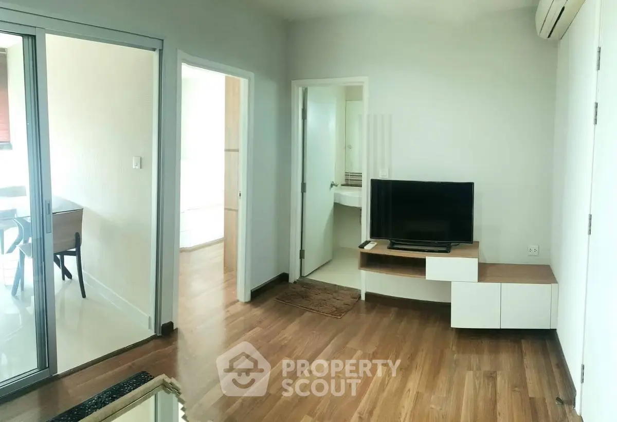 Modern living room with wooden flooring and sleek furniture in a contemporary apartment.