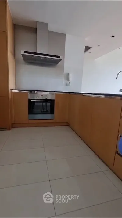 Modern kitchen with sleek cabinetry and built-in oven, perfect for culinary enthusiasts.