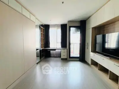 Spacious modern living room with built-in storage and large window for natural light.