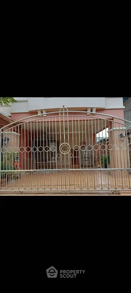 Elegant gated entrance of a modern home with stylish metalwork and welcoming facade.