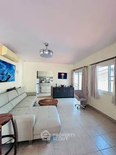 Spacious living room with modern decor and ample natural light.