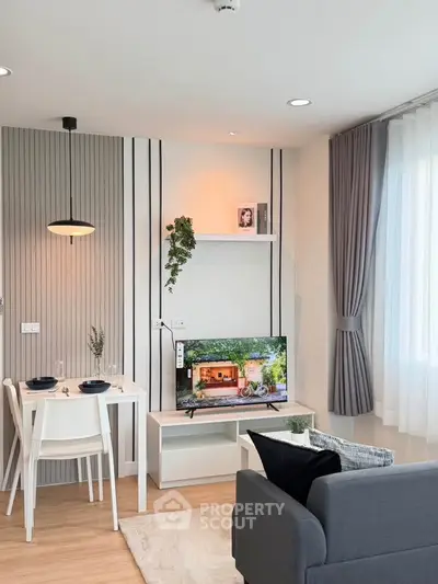 Modern living room with stylish decor, cozy seating, and natural light from large window.