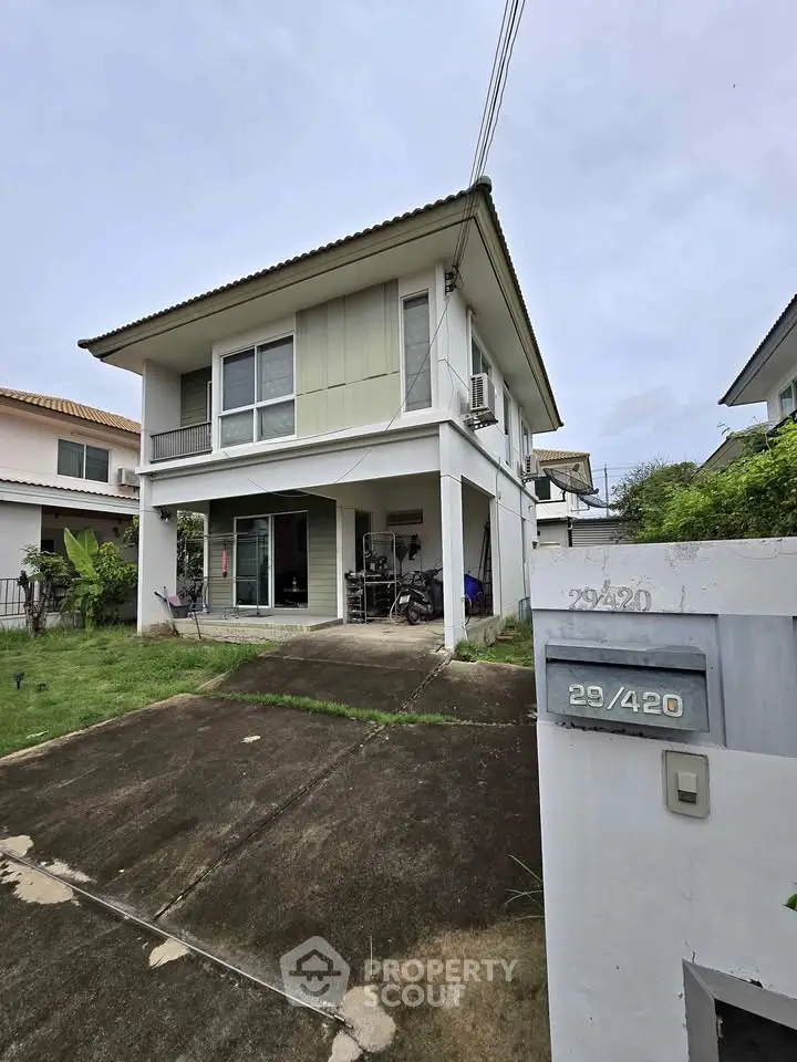 Charming two-story house with lush garden and spacious driveway in a serene neighborhood.