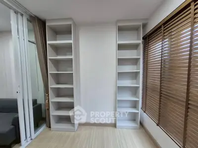 Modern living room with built-in shelves and large window blinds