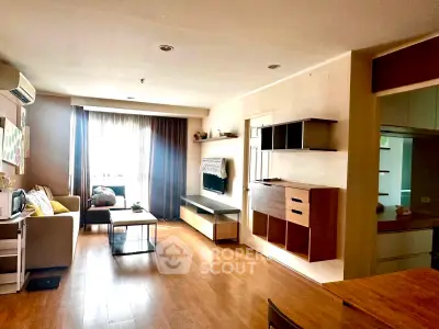 Spacious living room with modern decor and natural light in a stylish apartment.