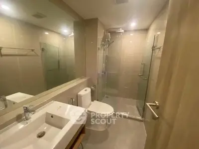 Modern bathroom with glass shower and sleek fixtures in a contemporary apartment.
