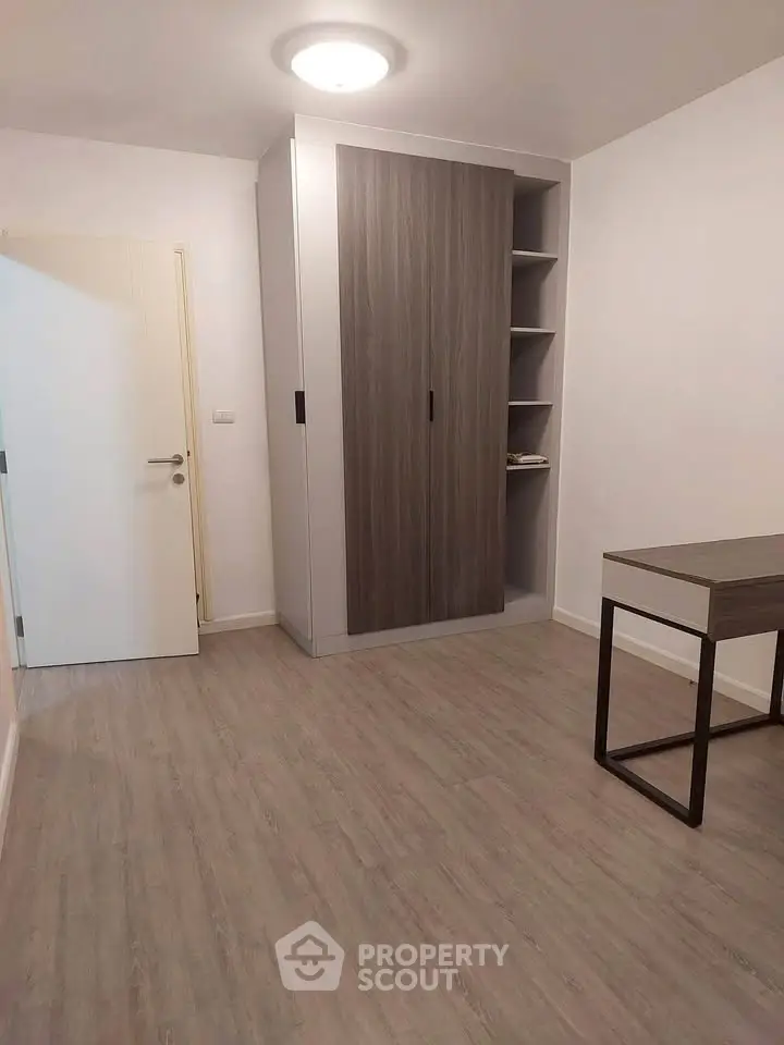 Modern minimalist bedroom with sleek wardrobe and desk, perfect for a stylish urban lifestyle.