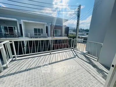 Spacious balcony with modern railing and city view, perfect for relaxation and outdoor enjoyment.