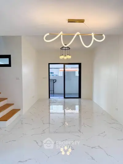 Modern living room with elegant lighting and marble flooring, featuring a balcony view.