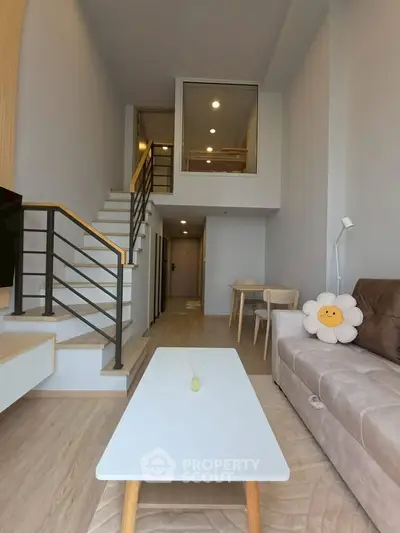 Modern loft-style living room with high ceiling and cozy decor