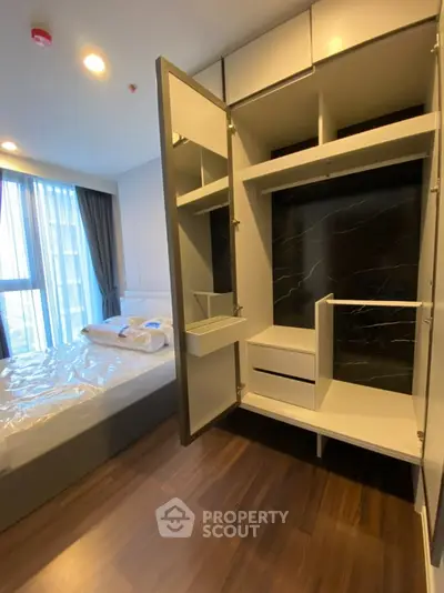 Modern bedroom with open wardrobe and large window view