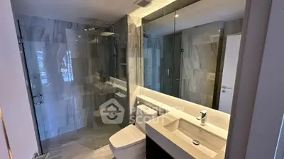 Modern bathroom with sleek design, glass shower, and elegant fixtures.