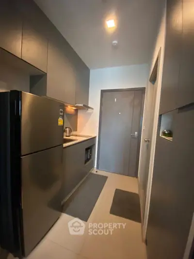 Modern kitchen with sleek cabinets and stainless steel appliances in compact layout.