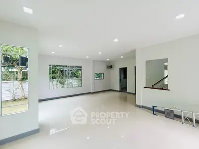 Spacious empty living room with large windows and garden view