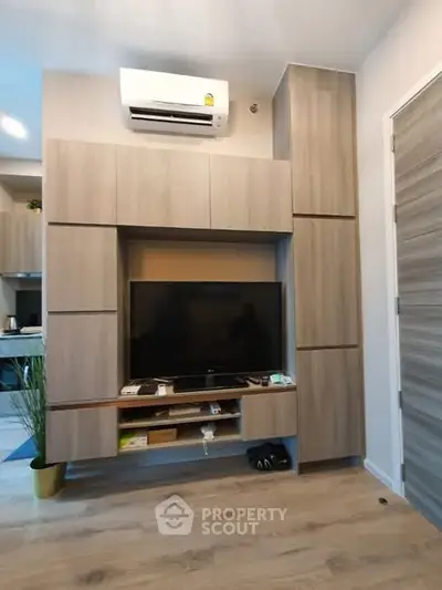 Modern living room with sleek wooden cabinetry and mounted TV