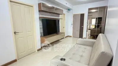 Modern living room with sleek furniture and large TV, perfect for relaxation and entertainment.