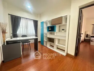 Modern study room with sleek desk and shelving, wooden flooring, and natural light.
