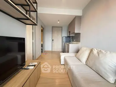 Modern living room with sleek furniture and open kitchen layout in a stylish apartment.