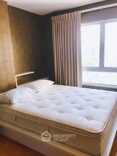 Cozy bedroom with large window and elegant curtains, perfect for relaxation.