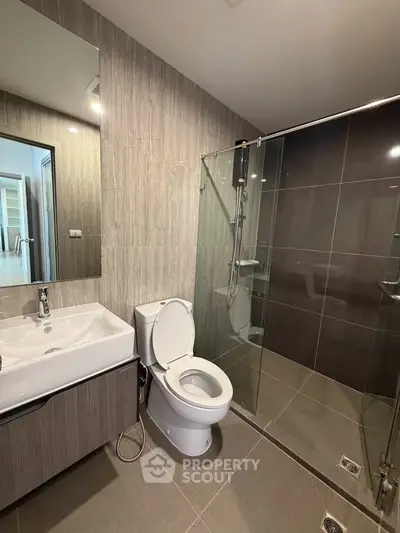 Modern bathroom with sleek design, featuring a glass shower and stylish vanity.