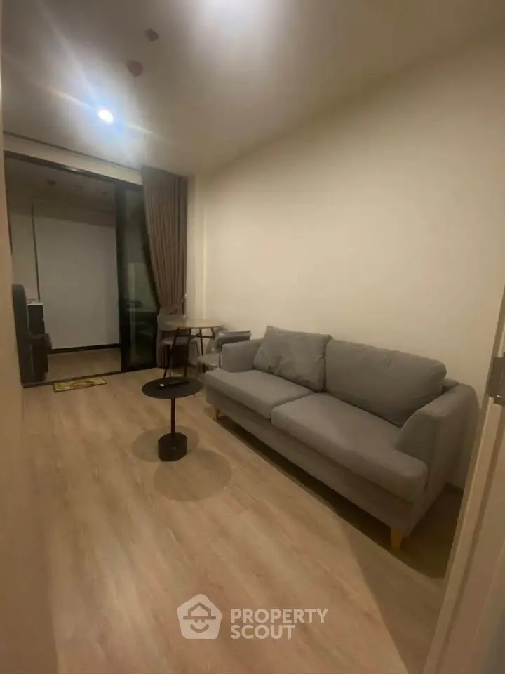 Cozy living room with modern sofa and wooden flooring, perfect for relaxation.