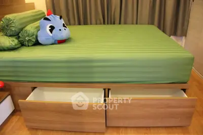 Modern bedroom with green bedding and built-in under-bed storage drawers.