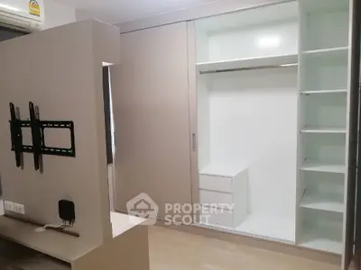 Modern minimalist living room with built-in wall shelving and TV mount, offering a sleek and functional space for urban living.