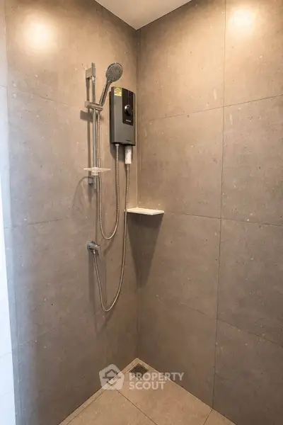 Modern bathroom with sleek shower design and minimalist gray tiles.
